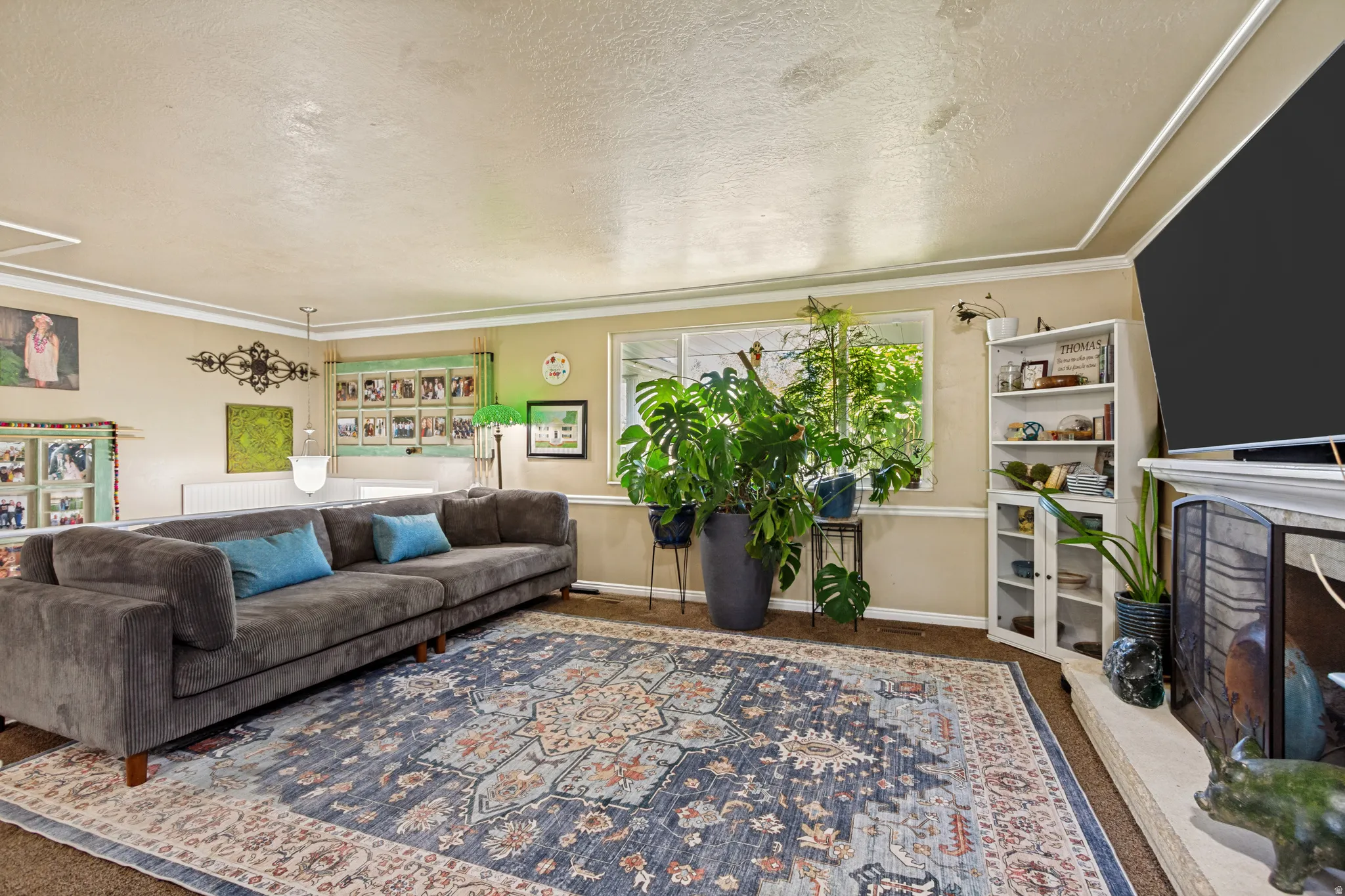 Hardwood flooring, crown molding, built-in shelving, and a fireplace with a hearth