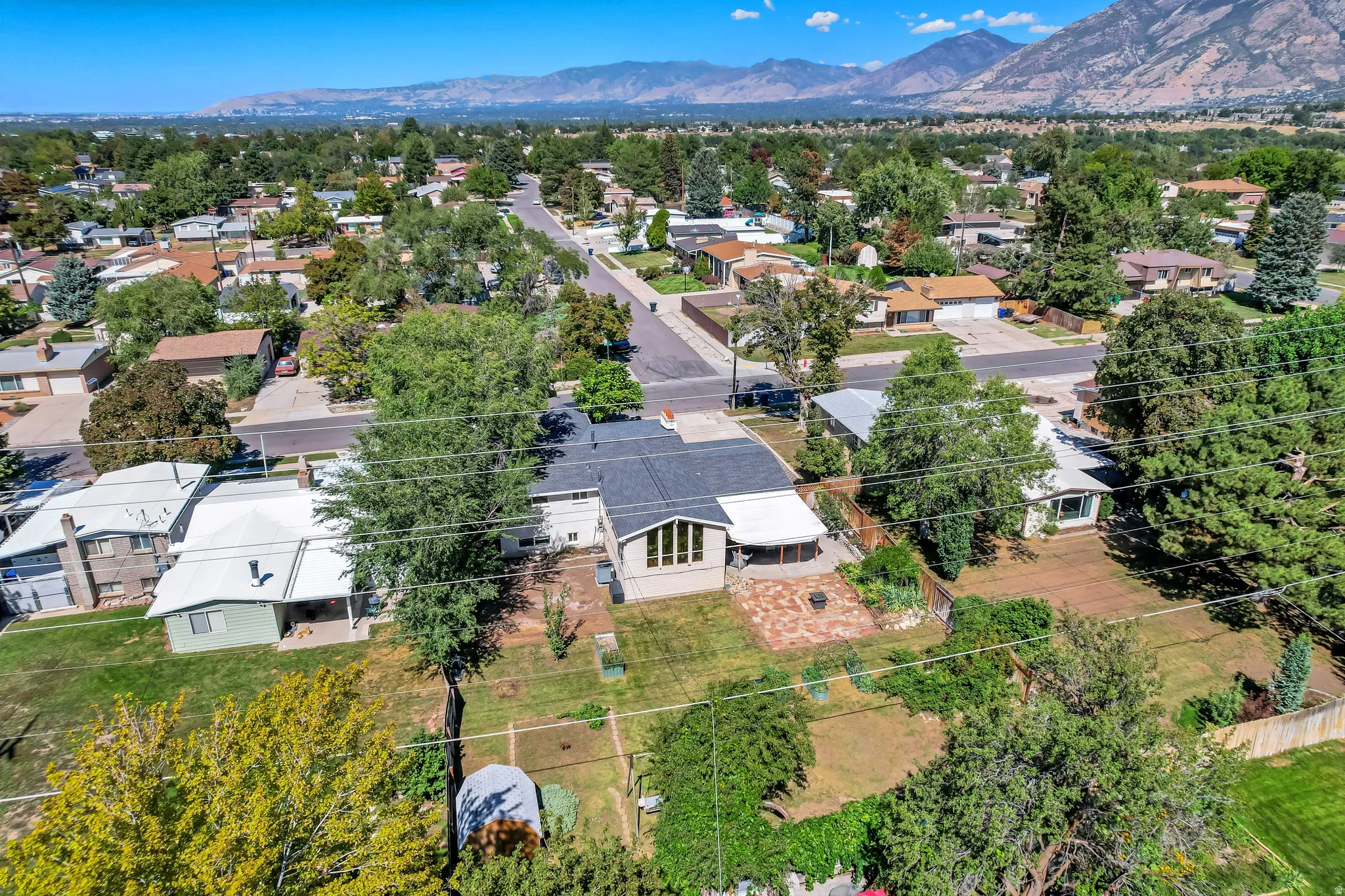 Property featuring a pitched roof, mature trees, an established neighborhood, and mountain scenery