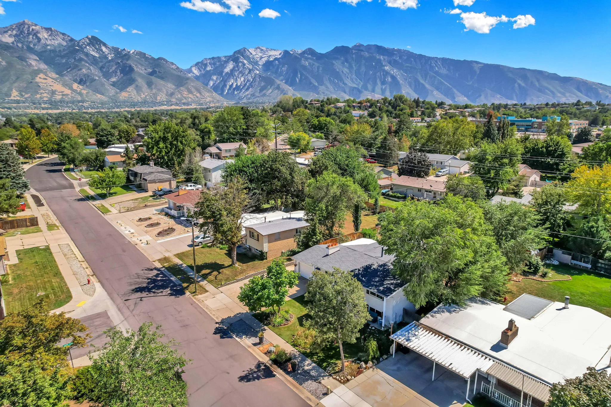 Expansive mountain backdrop with a residential neighborhood featuring mature trees and paved streets