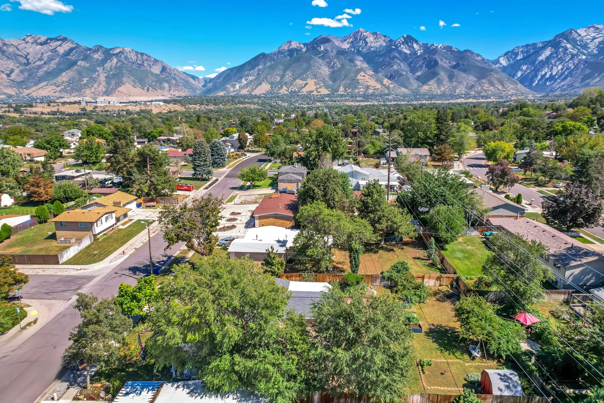 Neighborhood setting featuring mature trees and mountain scenery