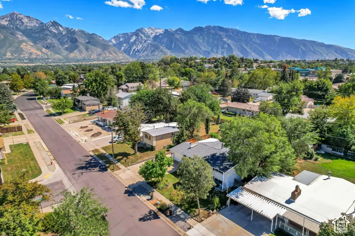 Expansive mountain backdrop with a residential neighborhood featuring mature trees and paved streets