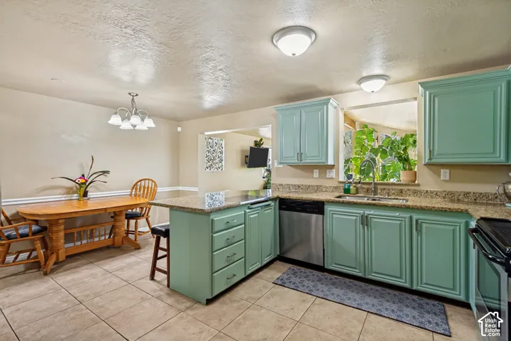 Kitchen featuring sage cabinetry, granite countertops, stainless steel appliances, and tile flooring