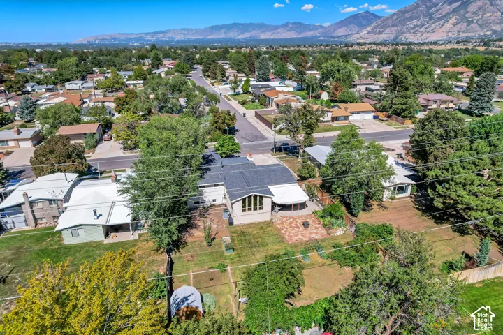 Property featuring a pitched roof, mature trees, an established neighborhood, and mountain scenery