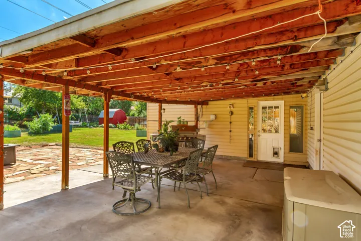 Covered patio with a concrete surface, exposed wood beam ceiling, and direct access to the interior