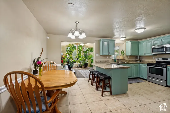 Kitchen featuring light blue cabinetry, stainless steel appliances, and a central island with a stone countertop