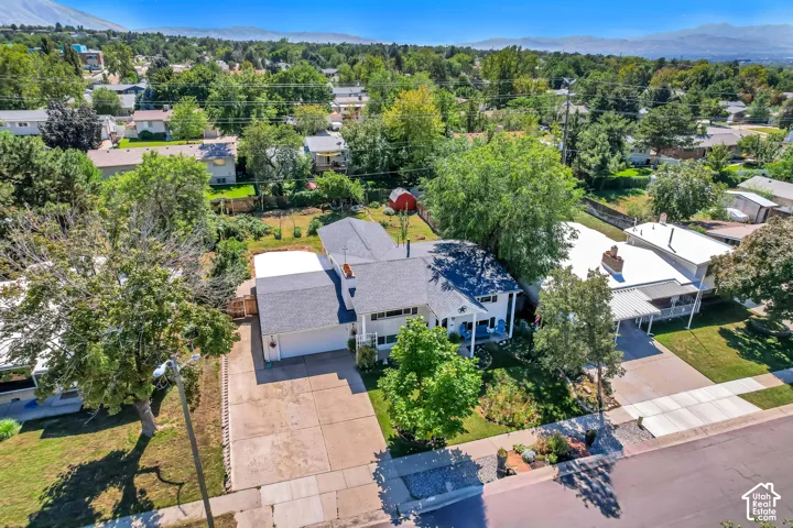 Expansive property featuring a two-story residence with a garage, mature trees, and a paved driveway