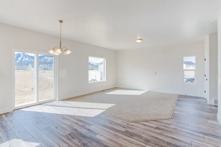 Wood-finish flooring, recessed lighting, and a multi-light brass chandelier