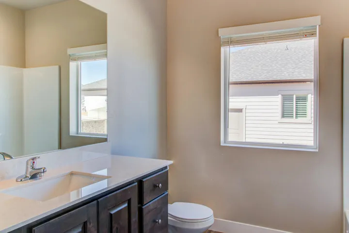 Vanity with an integrated rectangular sink, chrome faucet, and dark wood-finish cabinetry