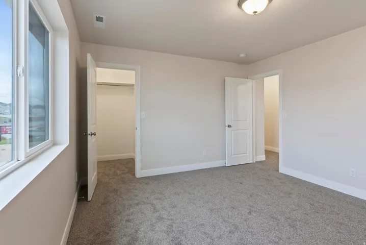 Neutral-toned carpeting, white trim work, and a semi-flush ceiling light fixture