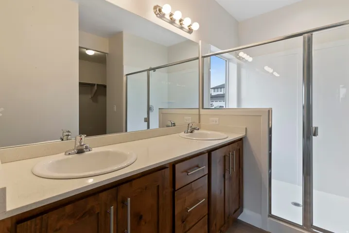 Dual vanity with undermount sinks, stone-finish countertop, and wood-finish cabinetry