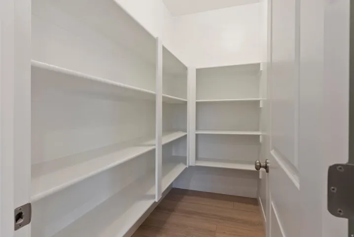 White built-in shelving, wood-finish flooring, and crisp white walls