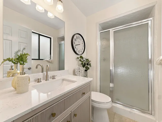 Vanity with a light-toned countertop, undermount sink, and brushed nickel faucet