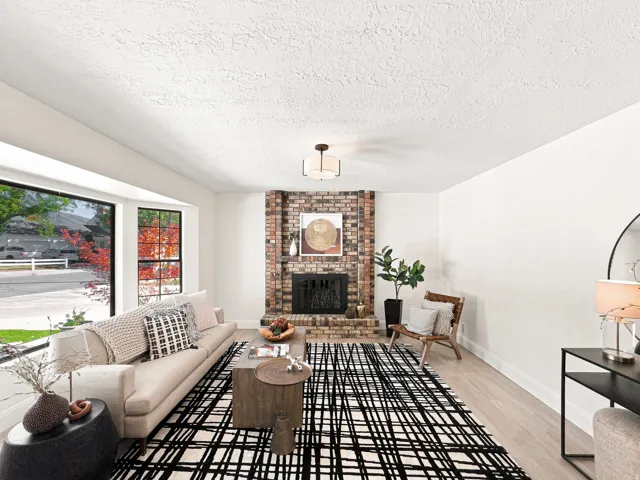 Expansive bay window, brick fireplace, wood-finish flooring, recessed lighting, and a modern ceiling fixture