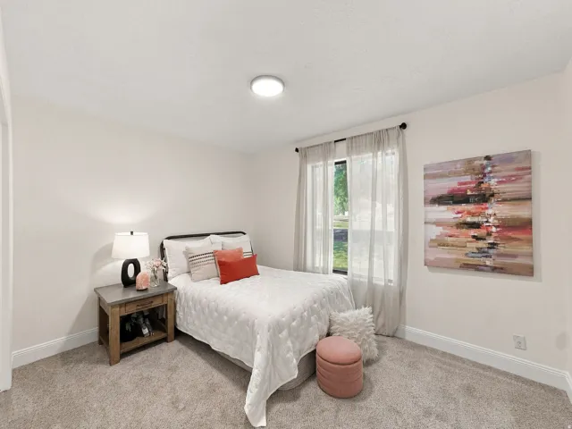 Neutral wall tones, recessed lighting fixture, carpeted flooring, and a window with natural light
