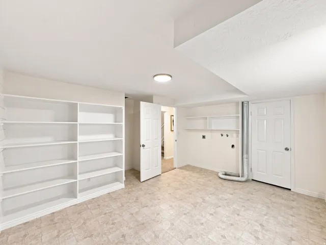 Built-in shelving, durable flooring, recessed lighting, and a utility area with shelving