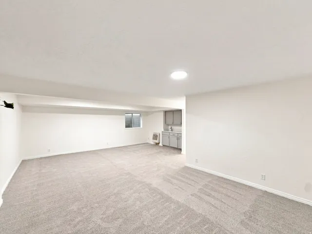 Spacious room with light gray carpet and recessed lighting