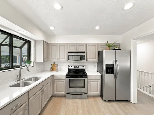 Kitchen featuring stainless steel appliances, light wood-finish flooring, white countertops, and recessed lighting