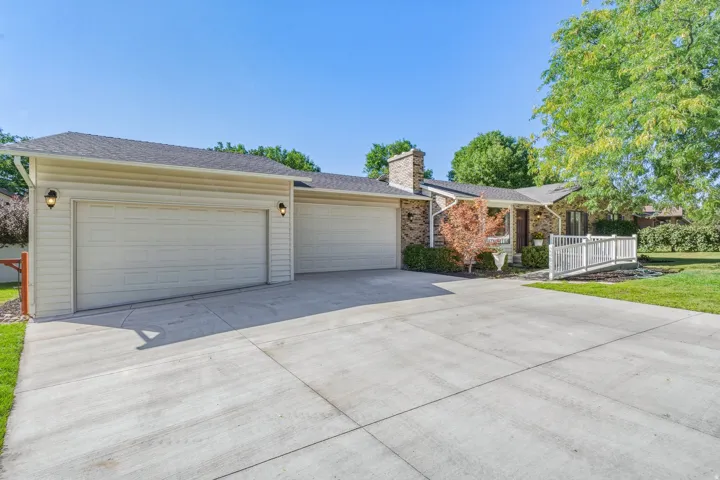 Brick and siding exterior with a multi-car concrete driveway