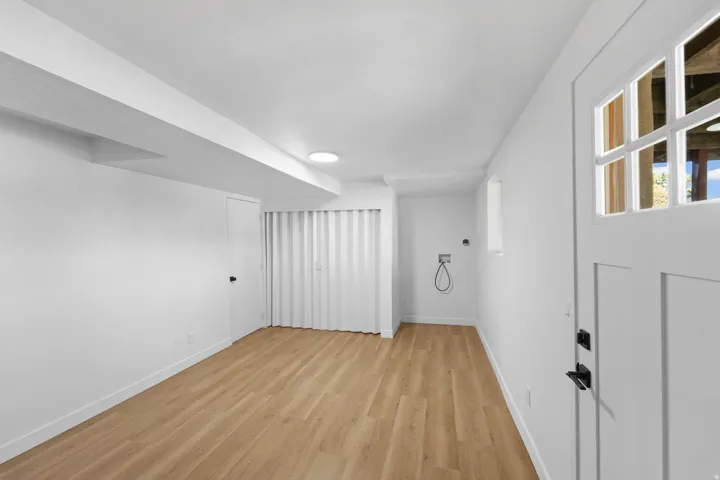 Wood-finish flooring, recessed lighting, white panel door, and laundry connections