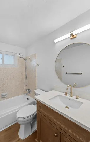 Wood-finish flooring with a white bathtub and toilet