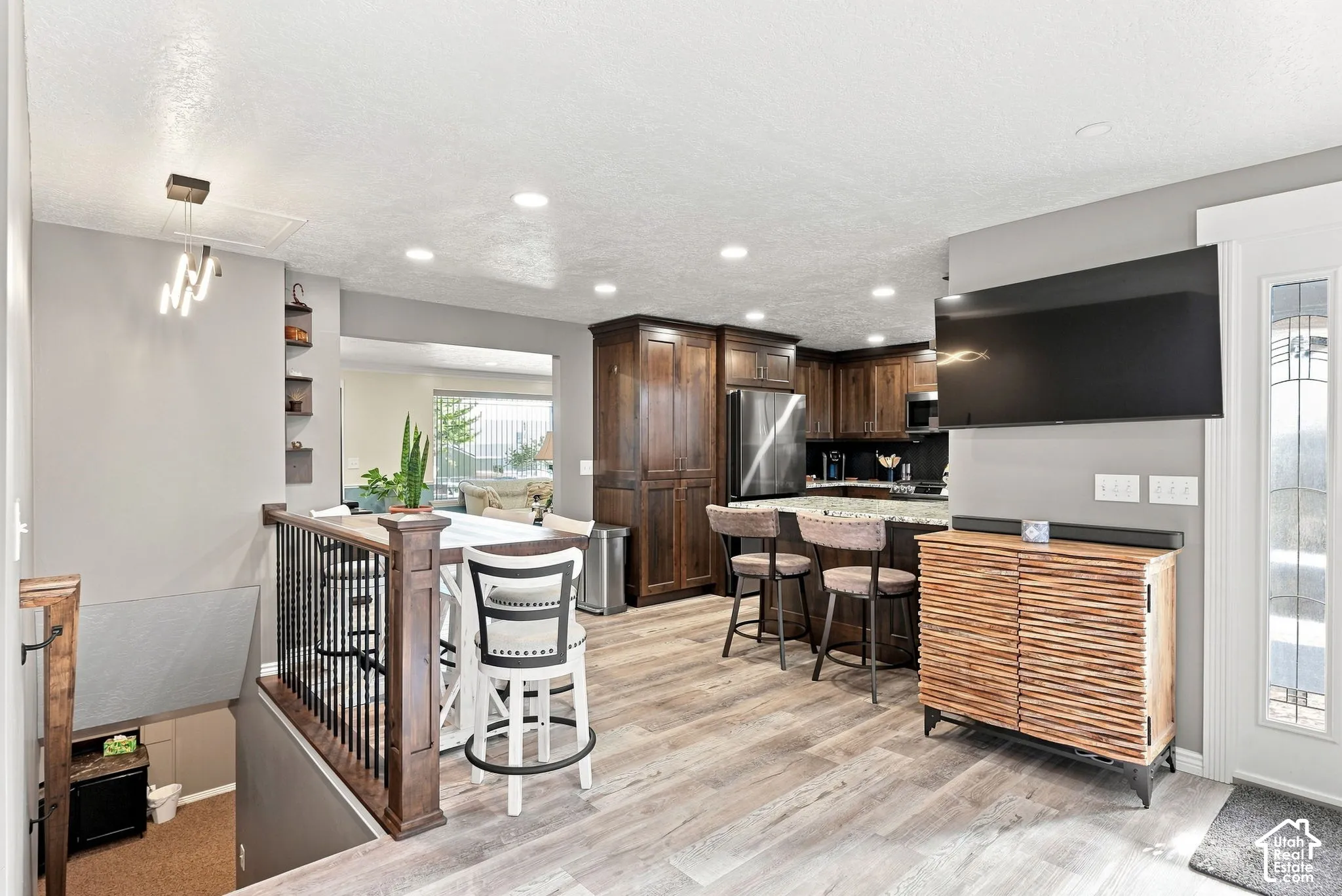 Kitchen with dark wood cabinetry, stainless steel appliances, and a granite-topped island with seating