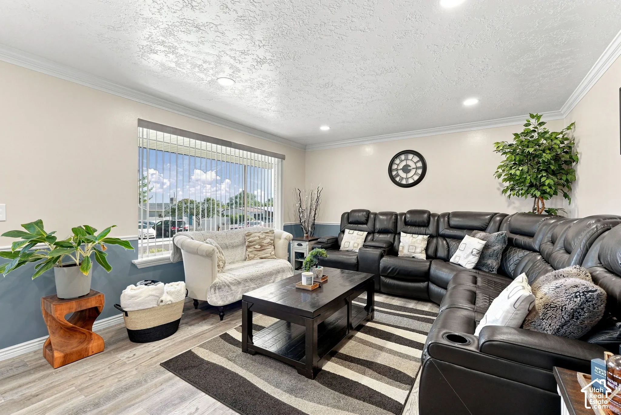 Recessed lighting, crown molding, wood-finish flooring, two-tone wall treatment, and a large window with vertical blinds
