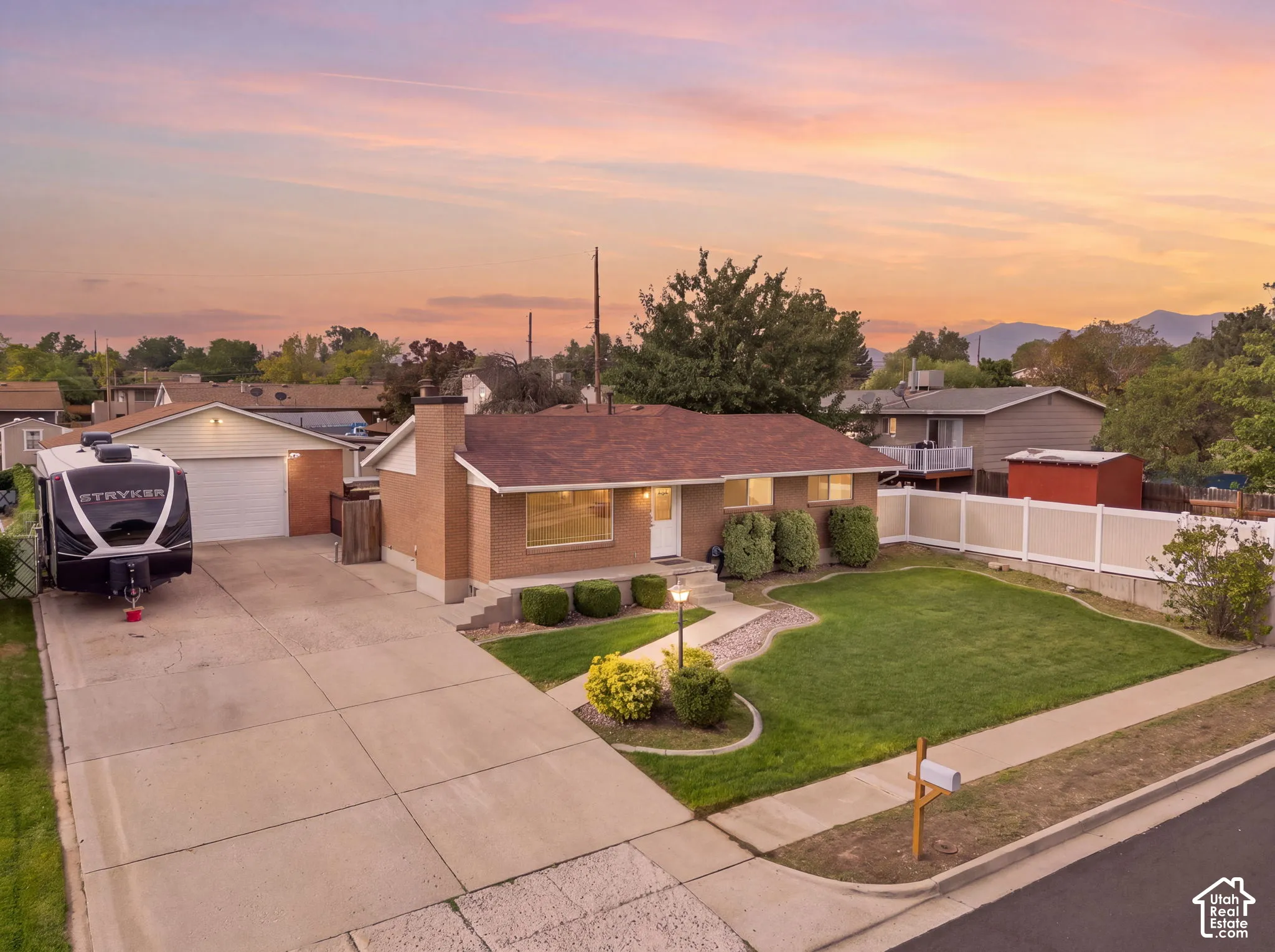 Brick exterior home with a shingle roof, a three-car garage, and a concrete driveway