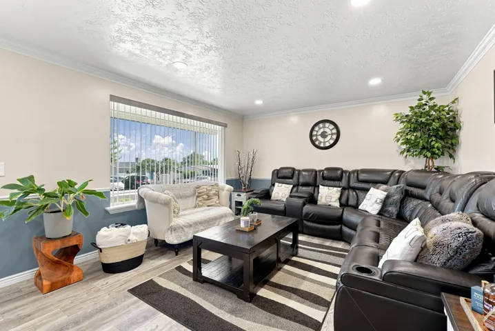 Recessed lighting, crown molding, wood-finish flooring, two-tone wall treatment, and a large window with vertical blinds