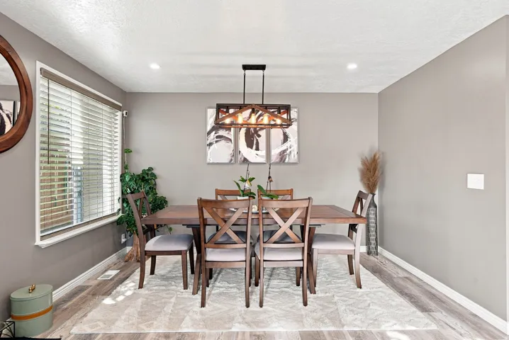 Recessed lighting, wood-finish flooring, and a window with blinds
