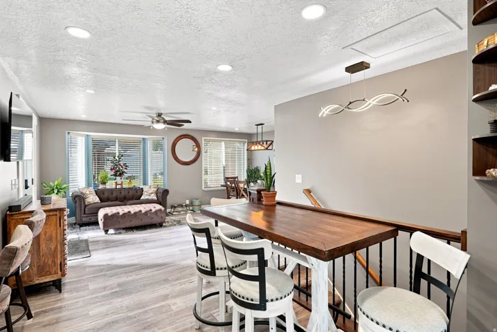 Open-concept living area featuring wood-finish flooring, recessed ceiling lighting, and a ceiling fan