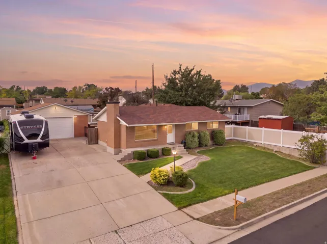 Brick exterior home with a shingle roof, a three-car garage, and a concrete driveway