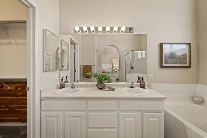 Dual vanity with integrated sinks, white cabinetry, and a light-toned countertop