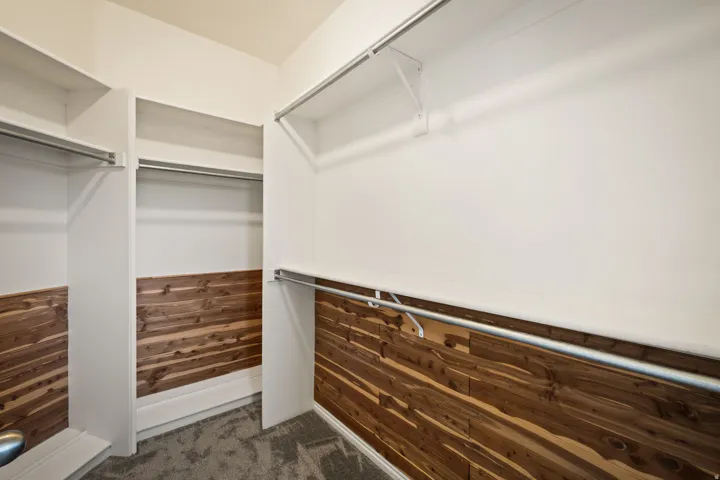 Cedar-lined closet featuring multiple hanging rods and built-in shelving