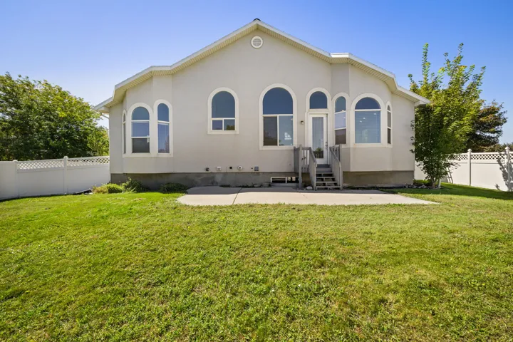 Rear stucco exterior with multiple arched windows and a central glass-paned door