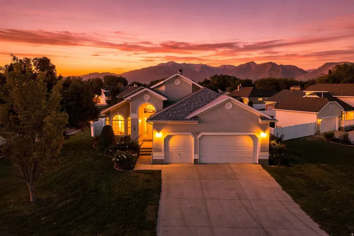 Stucco exterior with arched entryway, two-car garage, and concrete driveway