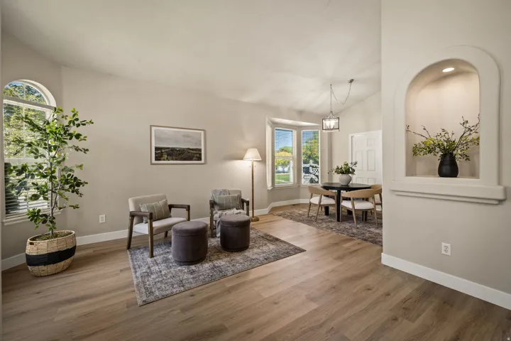 Wood-finish flooring throughout, vaulted ceilings, arched transom window, and a built-in arched wall niche with integrated lighting