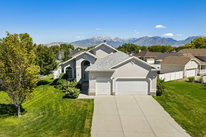 Stucco exterior with an arched entryway, two-car garage, and a concrete driveway