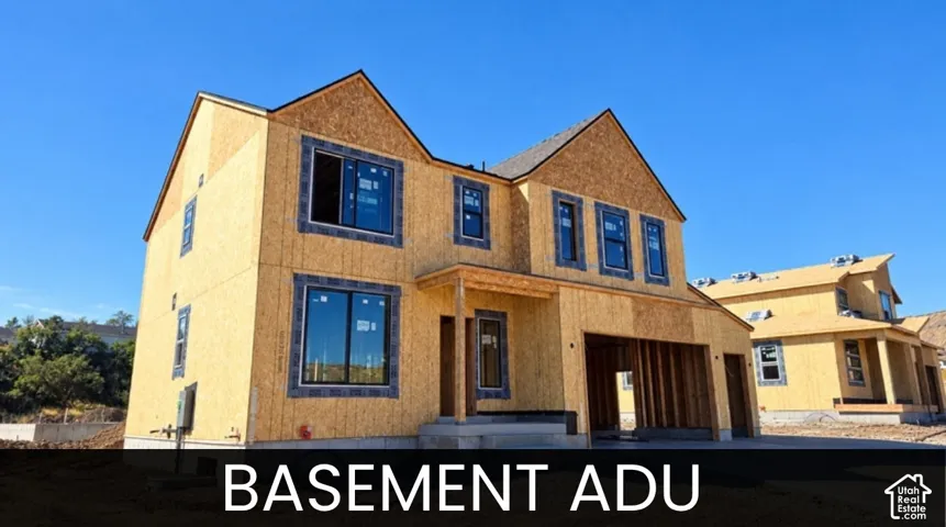 New construction framing with multiple windows, an attached garage, and a covered entry