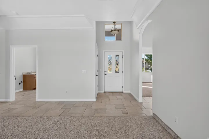 Foyer with decorative glass panel door, transom window, and integrated overhead lighting