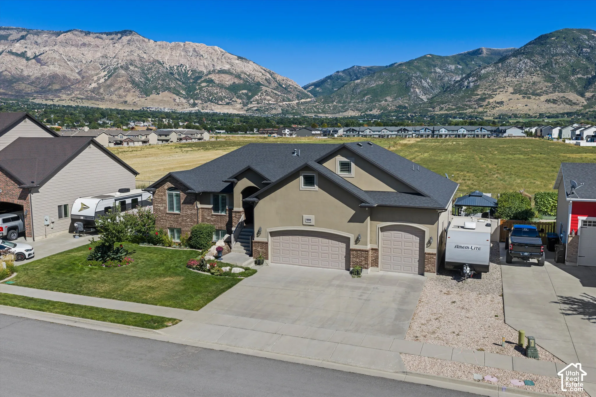 Contemporary exterior with a two-car garage, brick and stucco facade, concrete driveway, and landscaped front yard