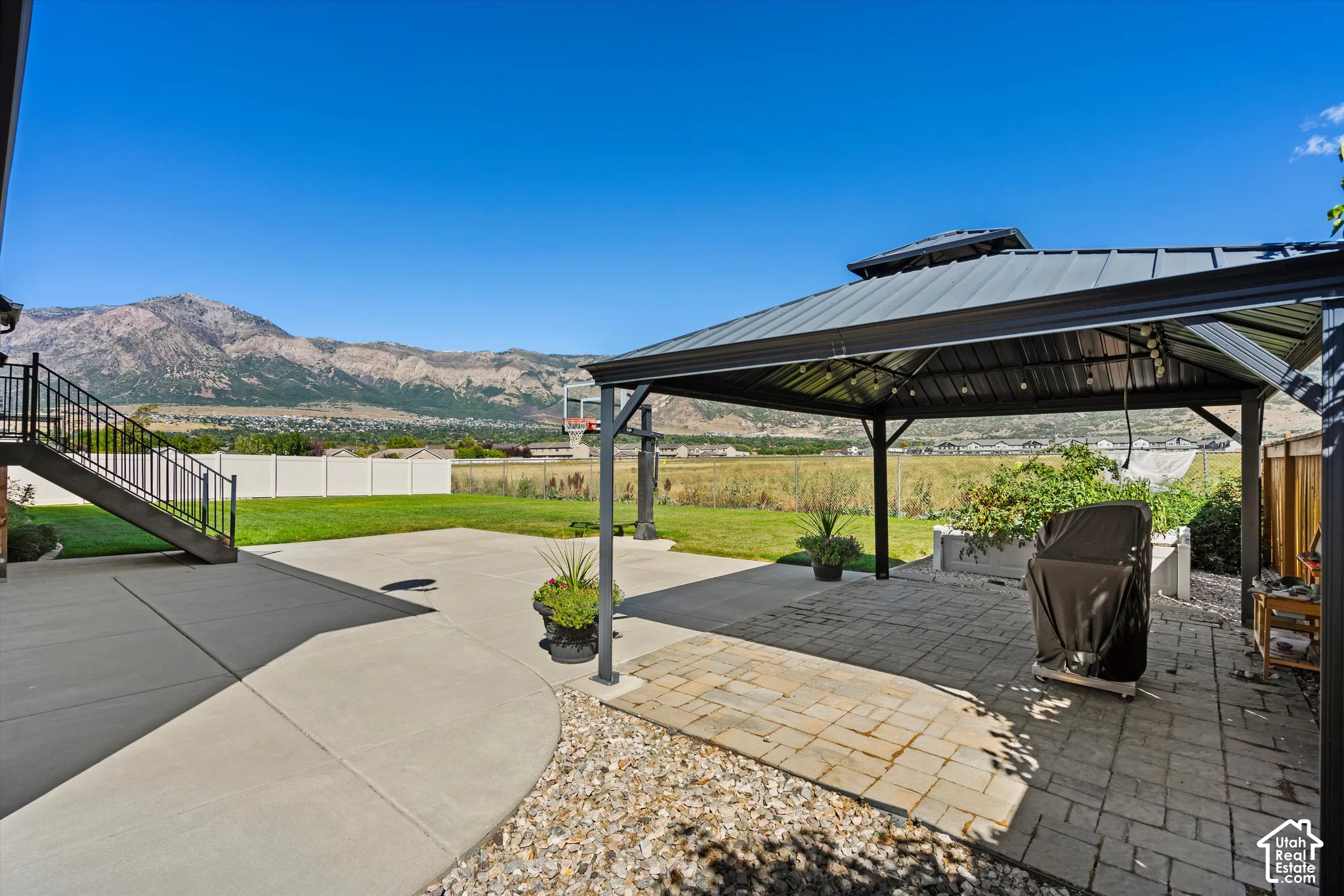 Expansive concrete patio with a paved section and an attached gazebo