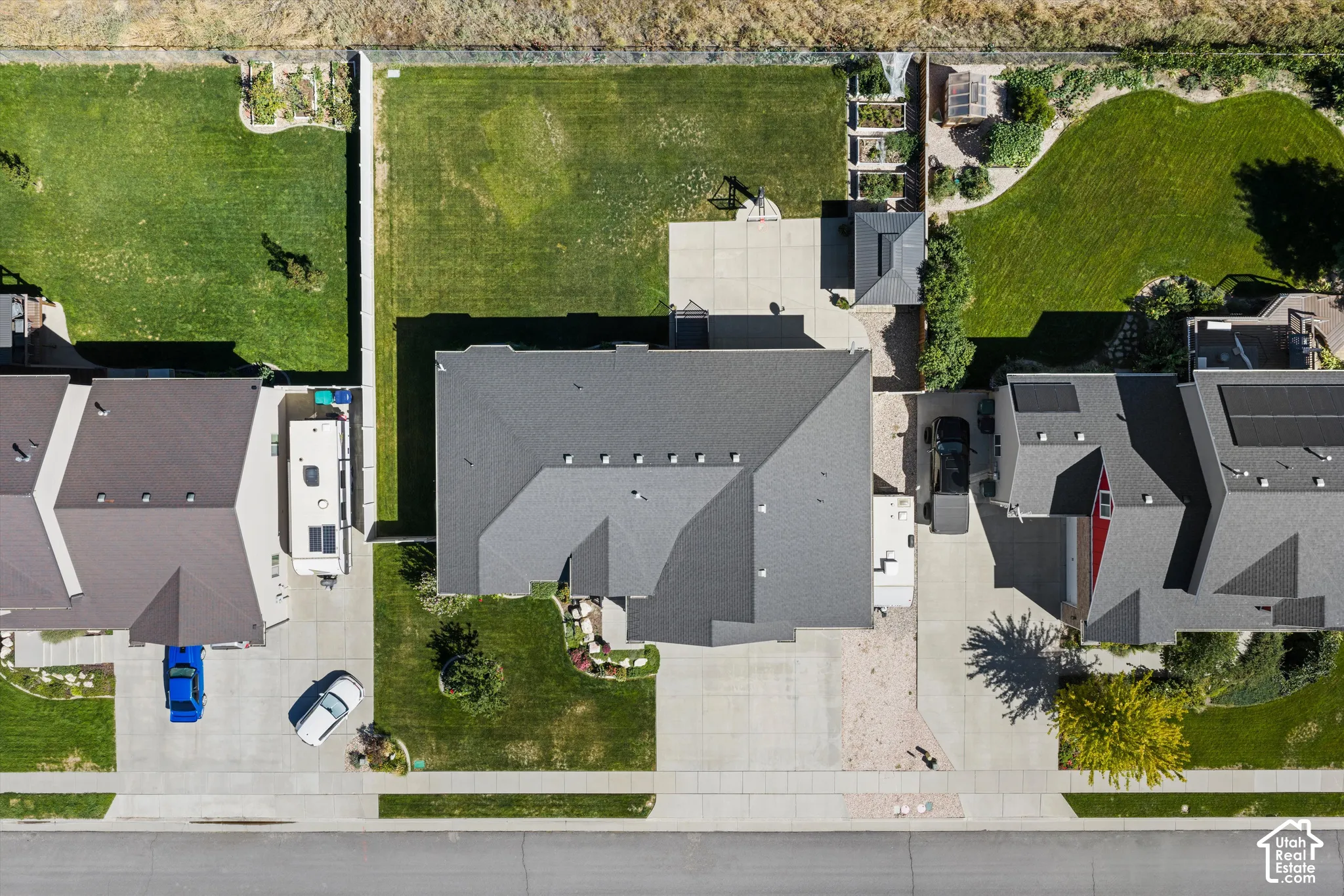Expansive property featuring a dark shingle roof, concrete driveway, and a generously sized grassy lawn