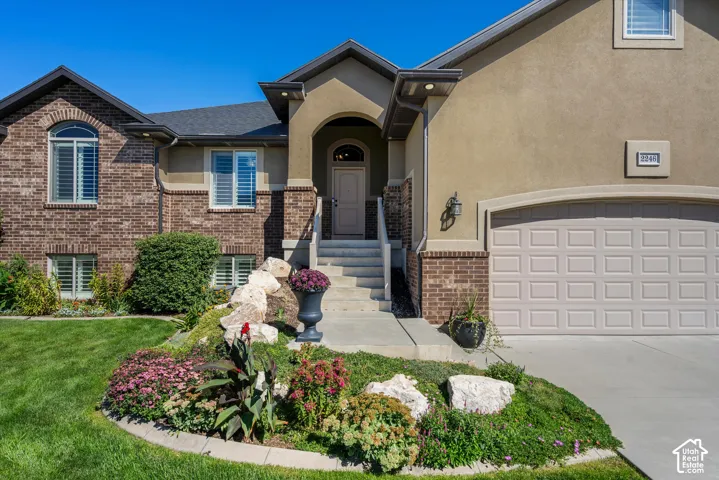 Brick and stucco facade with a covered entry, prominent arched window, and attached garage