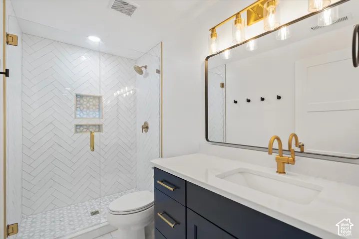 Glass-enclosed shower with chevron-patterned wall tile and a recessed niche