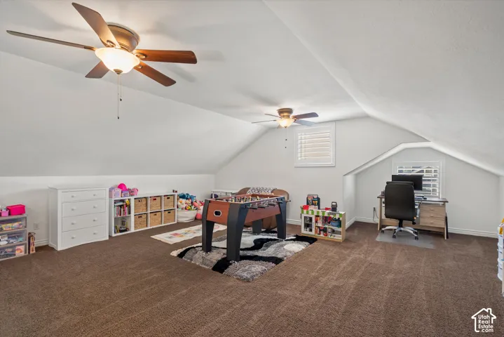 Spacious room with sloped ceilings and brown carpeting