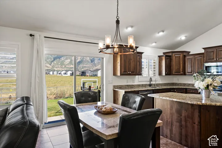 Kitchen featuring wood cabinetry, granite countertops, an island, and recessed lighting