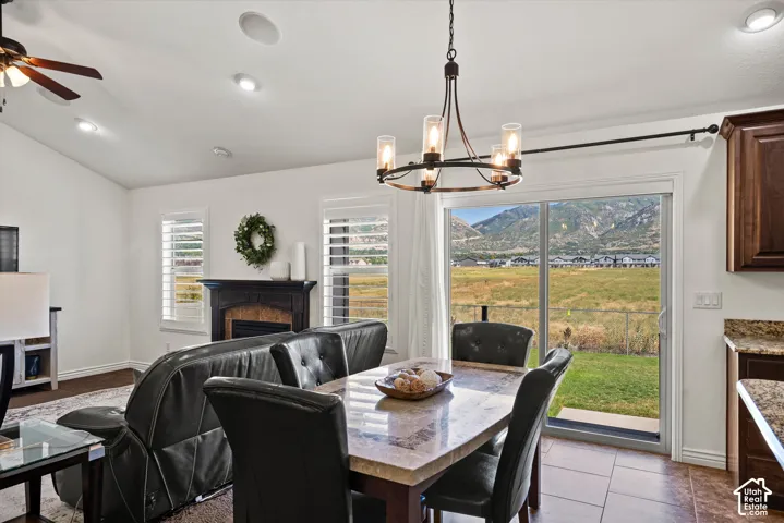 Sliding glass door leading to outdoor space, built-in fireplace with mantel, window shutters, recessed lighting, and a ceiling fan