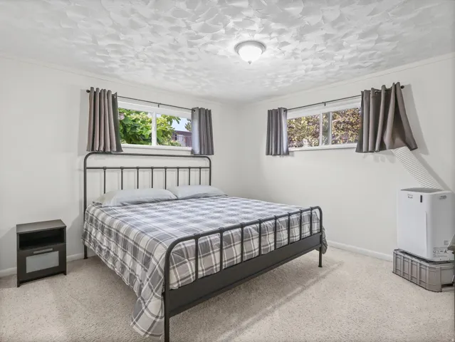 Carpeted flooring, white wall finishes, and a textured ceiling