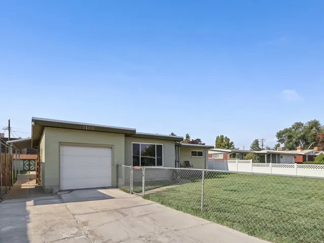 Single-story residence featuring a front lawn and paved driveway