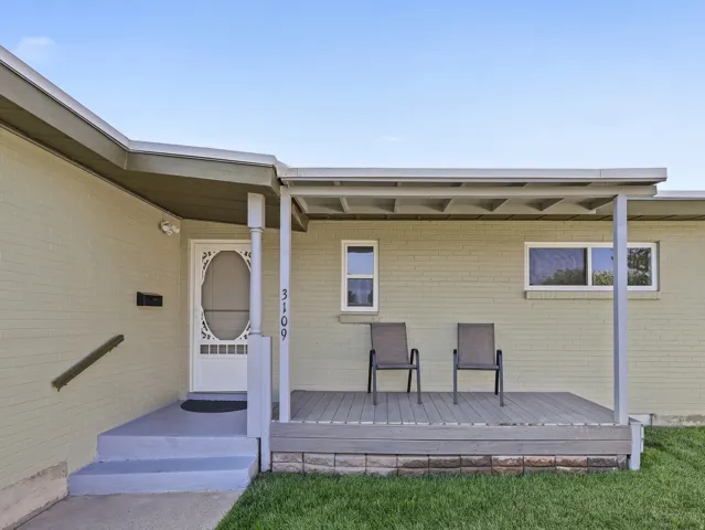 Exterior brick construction with a covered porch and deck